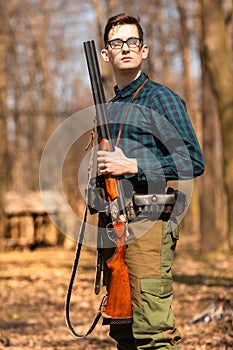 Autumn hunting season. Man hunter with a gun. Hunting in the woods