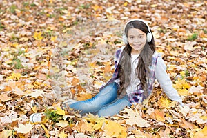 Autumn kid fashion. inspiration. happy childhood. back to school. girl among maple leaves relax in park. fall beauty in