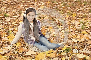 autumn kid fashion. inspiration. happy childhood. back to school. girl among maple leaves relax in park. fall beauty in