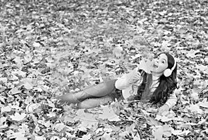 autumn kid fashion. inspiration. happy childhood. back to school. girl among maple leaves relax in park. fall beauty in