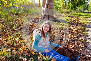 Autumn kid girl with pet dog relaxed in fall forest