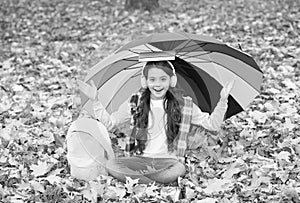 autumn kid under umbrella. read the book. happy childhood. back to school. girl in headset with backpack relax in park
