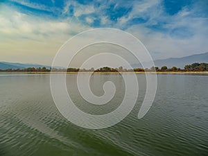 Autumn on Lake Kerkini - water, sky and hills dressed in fog - fantasy of gentle colors. Northern Greece.