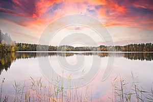 Autumn lake landscape with dramatic red skies