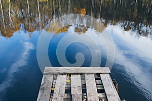 Autumn lake with an old wooden bridge