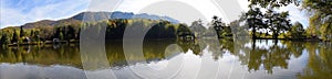 Autumn lake panorama with reflection of the trees