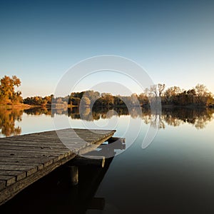 Autumn lake scene with wooden dock