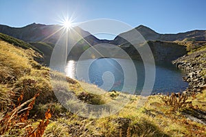 Autumn lake scenery with bright sunlight shining above Mount Tateyama