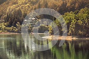 Autumn lake warm tones view building with reflections on water