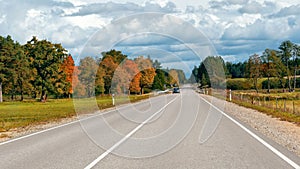 Autumn landscape with asphalt road and forest.