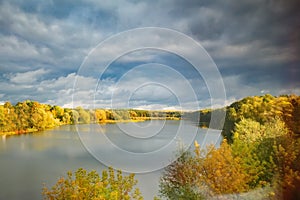 Autumn landscape beautiful colored trees over the river, glowing in the sunlight. beautiful picturesque background.