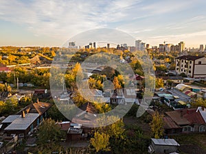 Autumn landscape on the city from the side of the ghetto with old dilapidated houses on the background of high