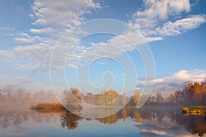 Autumn landscape and foggy lake