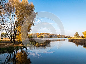 Autumn landscape. forest lake with colorful trees and water surface with sky reflections
