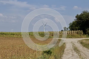 Autumn landscape with giant wind power turbines in a crop field