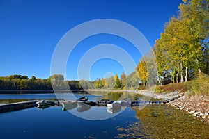 Autumn landscape with a lake, a boat bridge and some boats