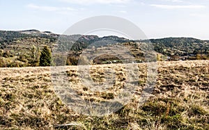 Autumn landscape with meadows, hills and blue sky