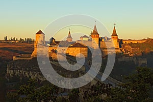 Autumn landscape of medieval Kamianets-Podilskyi castle during sunrise. Famous touristic place and travel destination in Ukraine.