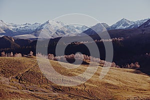 An autumn landscape of mountains on a trip with snow-covered winter peaks in the background