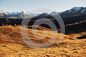 Autumn landscape of the nature of the mountains on a trip with snow-capped winter peaks in the background, off roads