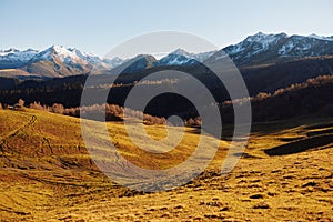 Autumn landscape of the nature of the mountains on a trip with snow-capped winter peaks in the background, off roads