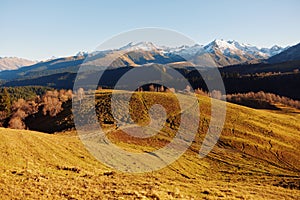 Autumn landscape of the nature of the mountains on a trip with snow-capped winter peaks in the background, off roads