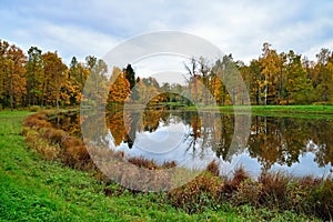 Autumn landscape with pond and trees reflected in formal Alexander Park of Tsarskoye Selo