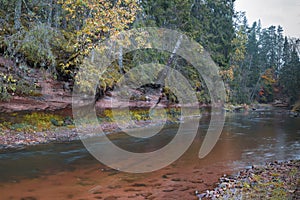 Autumn landscape and red stone cliff of Amata river, Latvia, Europe.