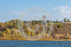 Autumn landscape, river,   windy weather, dark blue water, yellow-red autumn leaves on trees, last warm days