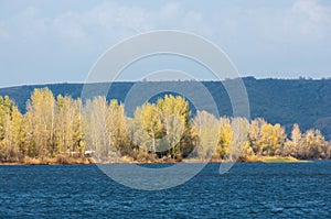 Autumn landscape,   river, windy weather, dark blue water, yellow-red autumn leaves on trees, last warm days