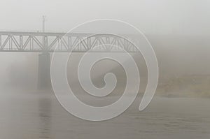 Autumn landscape. Strong fog over the river. Bad visibility. Danger on the sea route. Railway bridge in the distance. Terrible