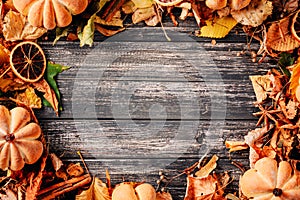 Autumn leaves border on the wooden background. Colorful foliage frame