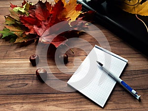 autumn leaves and chestnuts on a wooden table