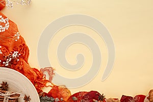 Autumn leaves, cinnamon and flowers on yellow background