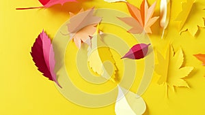 Autumn leaves cut out of paper are spinning in a circle on a yellow background. Autumn Concept