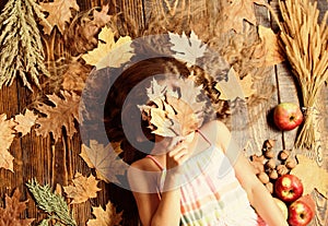 Autumn leaves are falling down. Little girl with wavy hairstyle on fall background. Pretty girl with long hairstyle