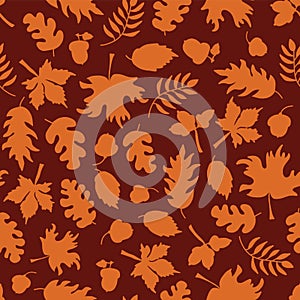 Autumn leaves seamless vector background. Orange leaf silhouettes on a red background. Acorns, oak tree, maple tree pattern.