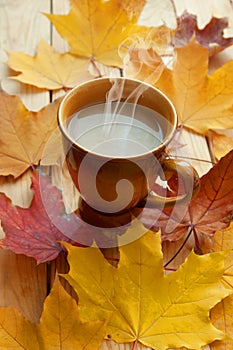 Autumn leaves in table, cup of hot coffee, autumn mood concept