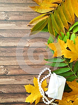 Autumn leaves on a wooden beads gift box surprise vertical