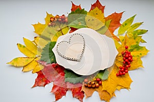 Autumn leaves with wooden heart. Symbol for loving autumn season. Autumn mood. Seasonal sales. Autumn holiday.wedding