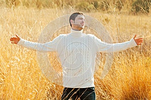 Autumn man in golden field with turtleneck sweater