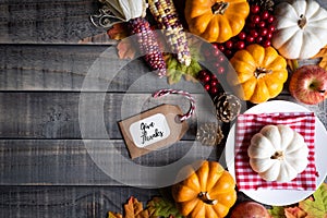 Autumn maple leaves with Pumpkin, apple, corn and red berries on old wooden background. Thanksgiving day concept