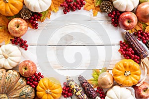 Autumn maple leaves with Pumpkin and red berries on old wooden background. Thanksgiving day concept