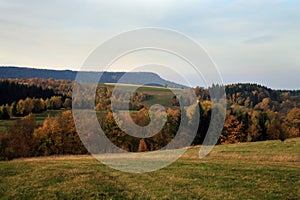 Autumn meadow and forest in small village Pasterka in Stolowe Mountains, Table Mountains, National Park in Poland. photo