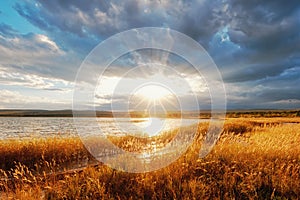 Autumn meadows lush grass and lakeside with the rays of the sun silence