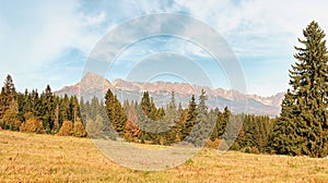 Autumn meadows near country road, panorama of Tatry mountains with Krivan peak Slovak symbol as seen from Vazec village, in