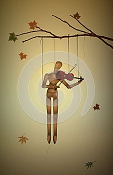 Autumn melancholy, November melody, marionette hanging on the tree branch and playing violine,