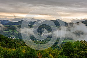 Fog rolling into the valley, autumn  landscape with forest.