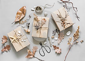 Autumn mood creative background. Homemade decoration gift boxes with natural materials on a light background, top view