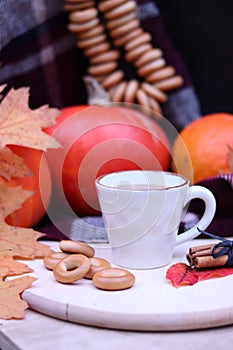 Autumn mood, a cup with a warm drink against the backdrop of ripe pumpkins